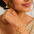 Pearl bangle with red and green stone accents, gold-toned, openable, 