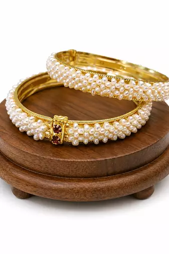 Pearl bangle set with red stone accents, gold-toned, openable, 