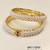 Pearl bangle set with red stone accents, gold-toned, openable, 