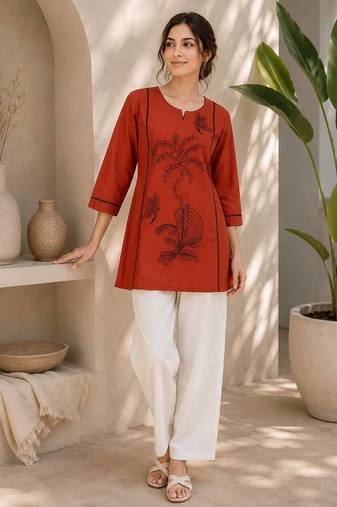  rust cotton kurta with black botanical embroidery and white trousers