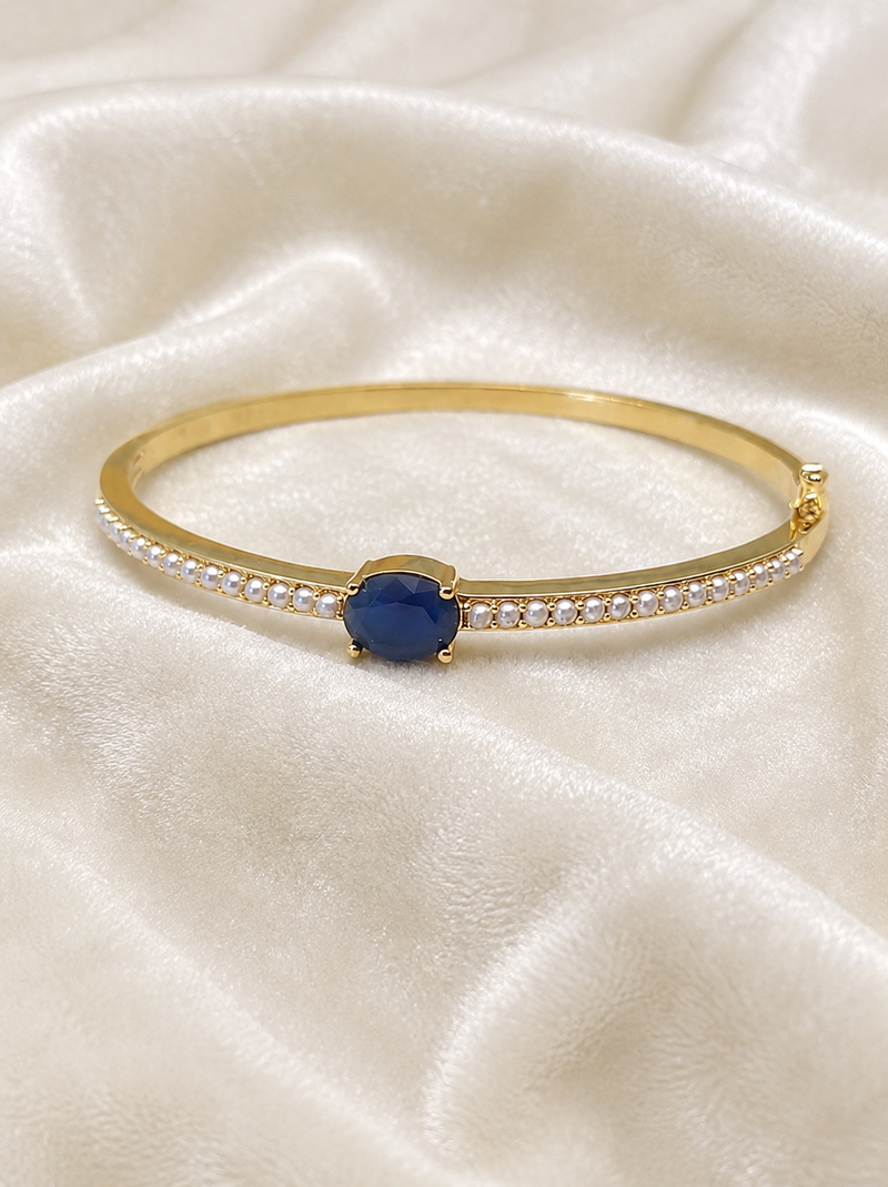 Gold-toned kada bangle with blue oval stone and pearl accents openable free size 
