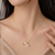 Gold-tone pearl pendant necklace with shell charm and crystal