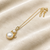 Double pearl pendant necklace with crystal charm, gold-tone