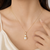 Double pearl pendant necklace with crystal charm, gold-tone