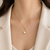 Gold-tone clover pearl pendant necklace with crystal accents