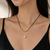 Layered pearl pendant necklace with black cord and gold chain