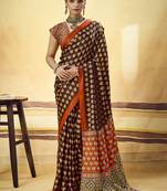 Brown satin printed saree with orange border and unstiched blouse