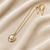 Gold-tone pearl pendant necklace with round swirl setting