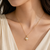 Gold-tone pearl pendant necklace with round swirl setting