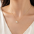 Pearl pendant necklace with ginkgo leaf design, gold chain