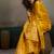 Mustard yellow linen silk blend saree with gold zari bootas and tassels