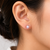 Pink freshwater pearl stud earrings with gold-tone backs pushing