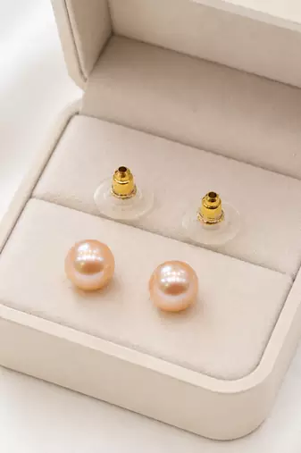 Pink freshwater pearl stud earrings with gold-tone backs