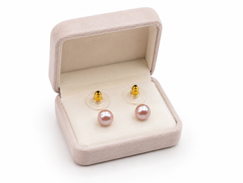 Pink freshwater pearl stud earrings with gold-tone backs pushing 1