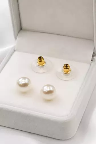 White pearl stud earrings with gold-tone push back clasps