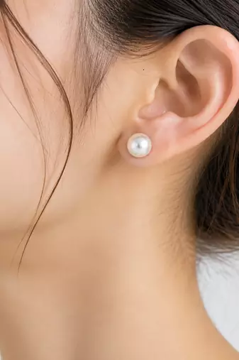 White pearl stud earrings with gold-tone push back clasps