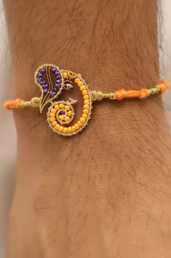 orange ganesha handcrafted beaded thread rakhi with roli chawal capsules