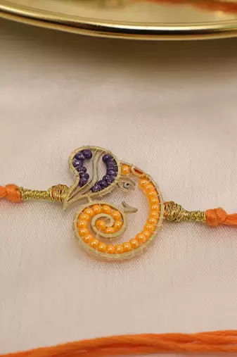 orange ganesha handcrafted beaded thread rakhi with roli chawal capsules