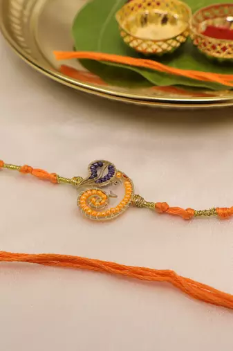 orange ganesha handcrafted beaded thread rakhi with roli chawal capsules