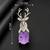 Silver-toned deer brooch pin with purple oval crystal stone