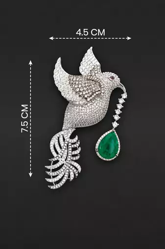 Silver-toned flying bird brooch with green teardrop crystal 