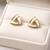 Triangle stud earrings with white enamel, gold tone geometric design, medium size, polished finish