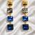 Gold tone square crystal drop earrings, blue and grey stones, dangle style, 4-tier design