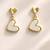 Gold-tone double heart drop earrings, white enamel pendant, stud back, dangle style