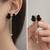 Black velvet bow stud earrings with gold chain tassel drop and ball ends, elegant dangle style