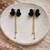 Black velvet bow stud earrings with gold chain tassel drop and ball ends, elegant dangle style