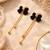 Black velvet bow stud earrings with gold chain tassel drop and ball ends, elegant dangle style