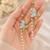 Blue enamel butterfly drop earrings with pearl chain tassel and crystal embellishments, gold-tone stud