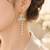 Blue enamel butterfly drop earrings with pearl chain tassel and crystal embellishments, gold-tone stud