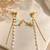 Blue enamel butterfly drop earrings with pearl chain tassel and crystal embellishments, gold-tone stud