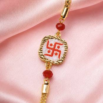 Traditional swastik charm rakhi with red beads 3