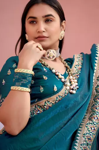 Fashionable teal blue embroidered border fandy satin saree with unstitched blouse