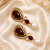 Gold tone black enamel wine statement earrings