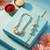 set of 2 gold toned & white pearls bhaiya bhabhi rakhi with roli chawal chandan mishri