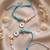 set of 2 blue evil eye & white pearl bhaiya bhabhi rakhi with roli chawal chandan
