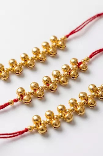 set of 3 gold toned ghungroo & red thread rakhi with roli chawal chandan mishri