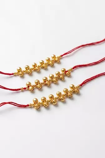 set of 3 gold toned ghungroo & red thread rakhi with roli chawal chandan mishri