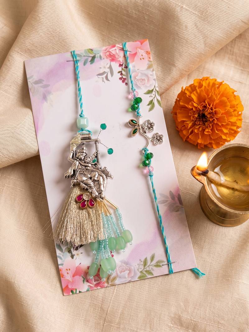 set of 2 designer religious silver toned bhaiya bhabhi rakhi with roli chawal chandan