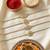 set of 4 white artificial stones & green thread rakhi with roli chawal chandan mishri