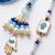 set of 2 evil eye hand design bhaiya bhabhi rakhi with roli chawal chandan mishri