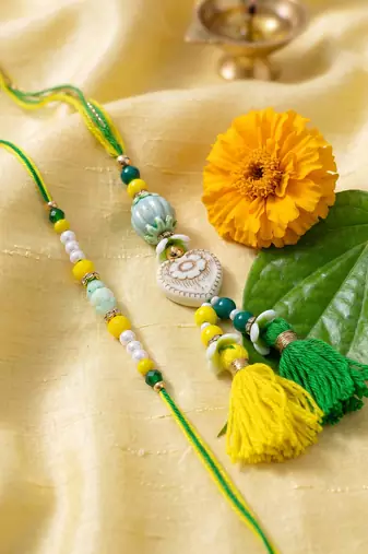 set of 2 green & yellow beaded heart shape bhaiya bhabhi rakhi with roli chawal