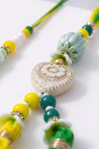 set of 2 green & yellow beaded heart shape bhaiya bhabhi rakhi with roli chawal