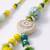 set of 2 green & yellow beaded heart shape bhaiya bhabhi rakhi with roli chawal