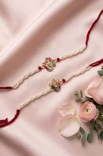 set of 2 white pearls om & ganesh ji thread rakhi with roli chawal chandan mishri