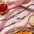 set of 2 silver toned beaded religious thread rakhi with roli chawal chandan mishri