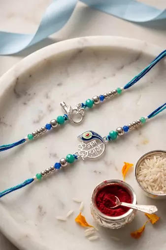 set of 2 silver toned beaded religious thread rakhi with roli chawal chandan mishri